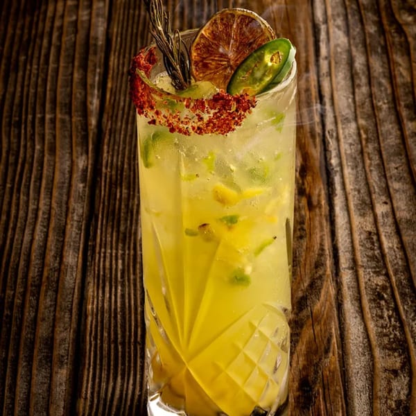 Okay Maguey's Mexican cocktail, garnished with chili-lime rim, dried orange, rosemary, and jalapeño slices.